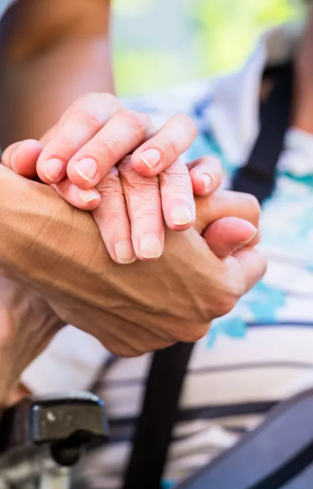A reassuring hand held by a caregiver